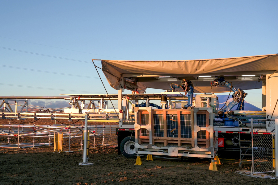 Mobile research platform with solar panels and robotic equipment set up outdoors at sunset.