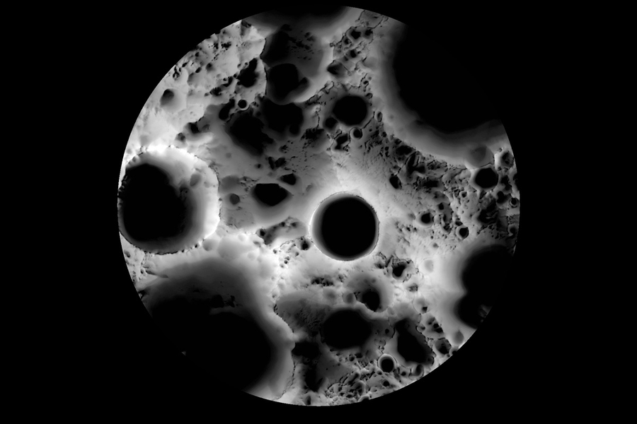 High-contrast black and white photograph of lunar surface showing multiple impact craters of varying sizes.