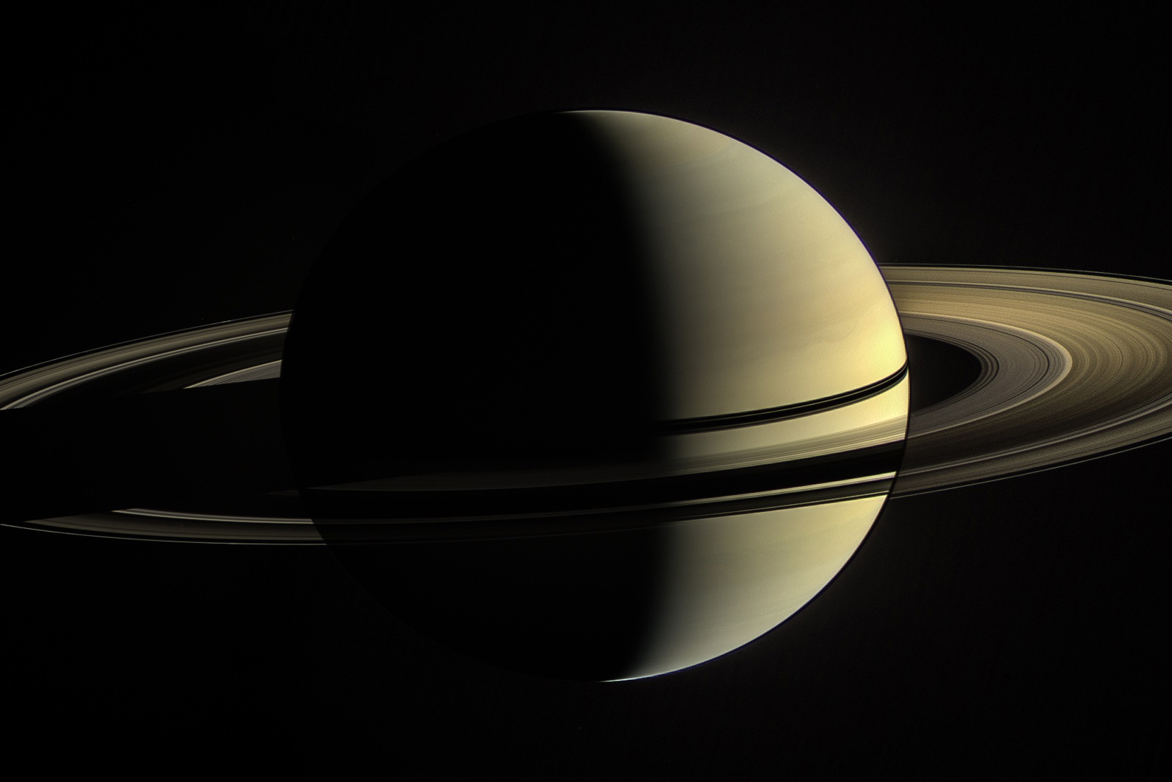 Saturn with prominent rings shown in three-quarter view against black space background.