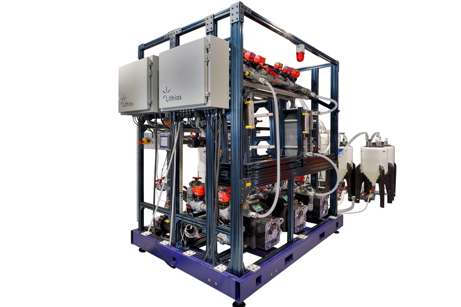 Industrial apparatus labeled Lithios with metal frame structure containing pipes, tanks, red valves, and equipment mounted on purple base platform.