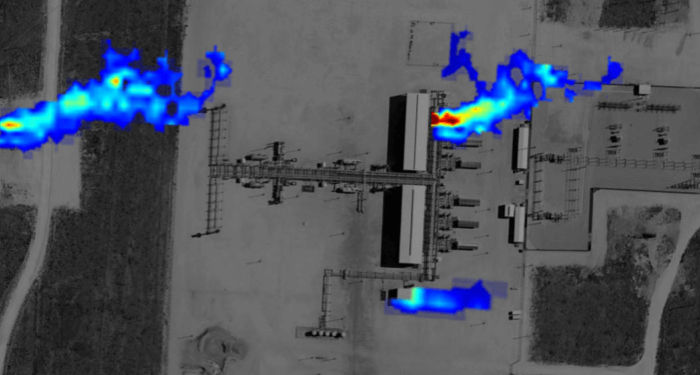 Aerial lidar scan of a natural gas facility overlaid with heat map showing methane emissions plumes in red, orange, and blue against a grayscale satellite image.