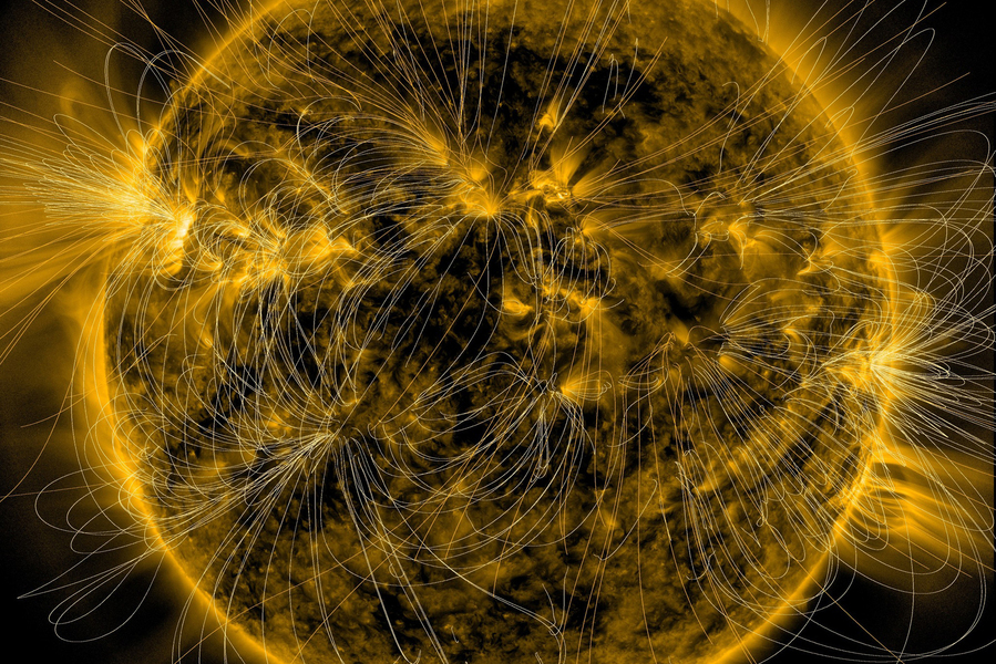 A close-up image of the sun's surface overlaid with white curved lines tracing its magnetic field patterns against a golden solar atmosphere.